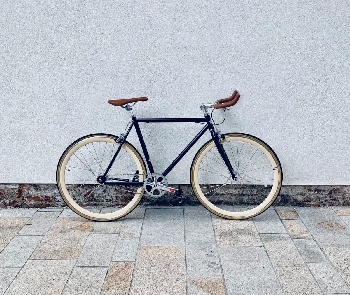 Bicicleta de estrada marrom e branca sobre piso de concreto